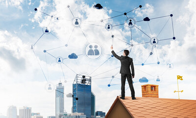 Businessman on house roof presenting networking and connection concept. Mixed media