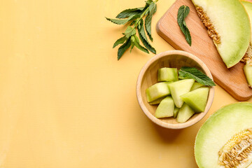 Bowl and board with pieces of sweet melon on yellow background - obrazy, fototapety, plakaty