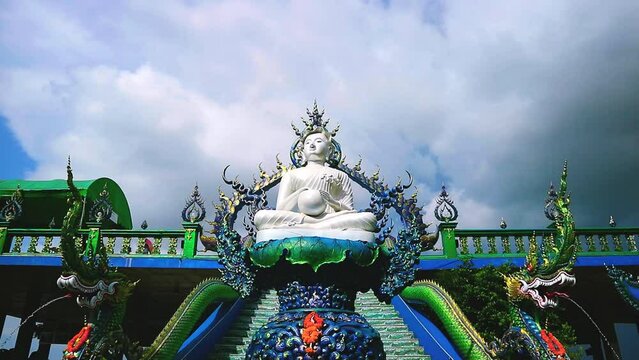 white sitting buddha dark cloud rolling background dark sky time lapse