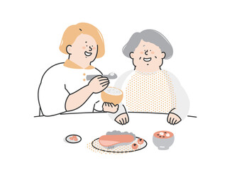 シニア女性の食事介助をする介護スタッフ