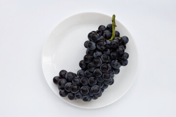 Fresh black grapes on white background.