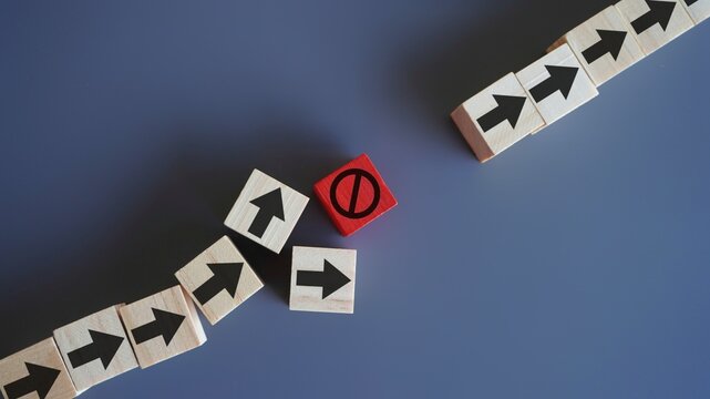 Wooden blocks with arrow and stop icon. Delays and disruptions, stop the process, critical error concept