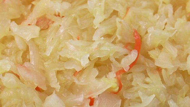 Top view of tasty sauerkraut from shredded cabbage and carrot texture circle rotation close up