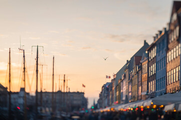 Fototapeta na wymiar Bird Flying over Colorful Nyhavn Street at Sunset