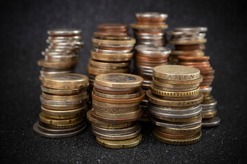 stacks of european currency coins,   on black glitter background