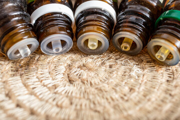 5 essential oil dropper bottles spilling in a line up on a jute rope circular placemat