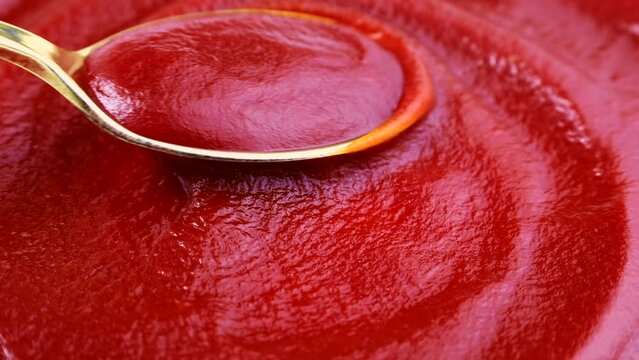 Red tomato ketchup in the mixing spoon close up
