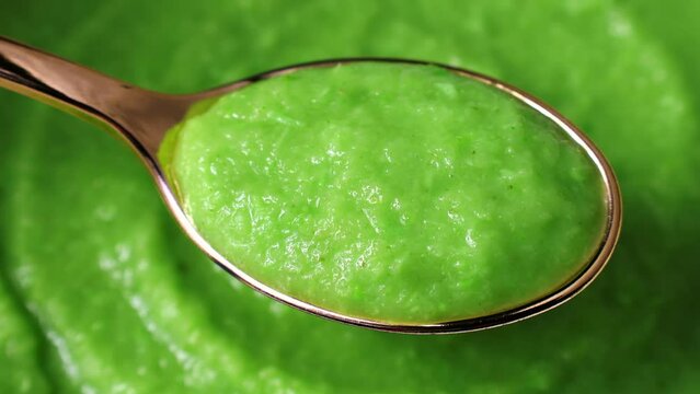 Bright green grated horseraddish wasabi spicy sauce in the spoon with circle rotation close up