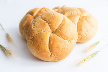 Bread rolls with wheat ears. on a white background. Close-up.