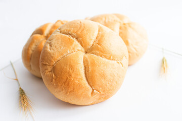 Bread rolls with wheat ears. on a white background. Close-up.