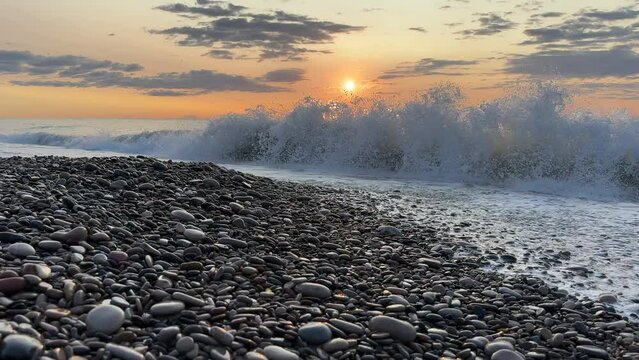 Waves in sea on sunrise. Pebble stone beach on sunset. Sea beach shore with waves in ocean. Empty coastline pebble beach. Sea beach landscape. Shore landscape on Spain resort. Ocean shoreline scenic.