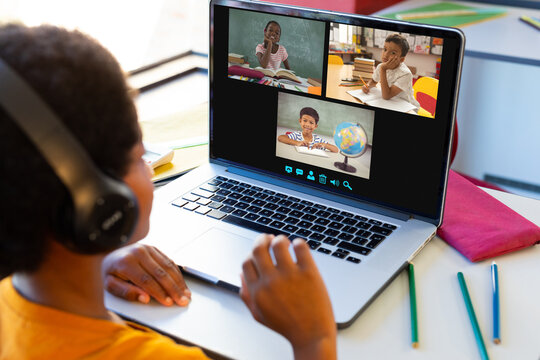 Happy diverse schoolchildren having class during laptop video call