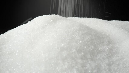 A macro video captures white sugar delicately cascading onto a sleek black background, enchanting viewers with its graceful descent. The probe lens offers a perspective, revealing intricate details
 - Powered by Adobe