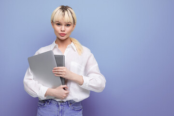 portrait of a young pretty blond secretary woman dressed in a white blouse with a working laptop and documents