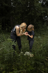 Family time in nature. Mother and daughter eating berries - 618052508