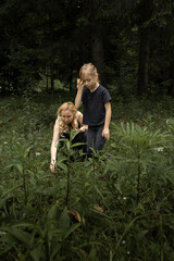 Mother and daughter in nature. Family time. Having fun picking berries in the forest - 618052561