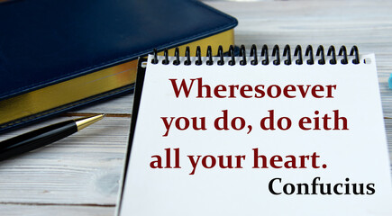 Wheresoever you do, do eith all your heart. Confucius- words in a notebook on the background of a weekly and a pen. © Zhanna
