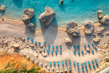 Drone view of beach chairs and blue sea in Greece