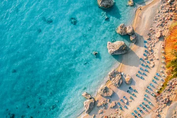 Tuinposter Strand zonsondergang Top view of beach chairs by turquoise sea in Greece