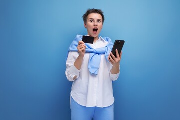 surprised stylish young brunette woman with short haircut with money card and smartphone mockup