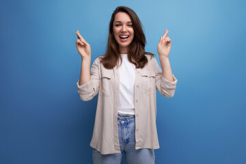 active 30s dark-haired woman in a beige shirt on a blue background