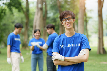 Fototapeta na wymiar Young Asian Volunteers with garbage bags cleaning park area. Ecology, Charitable organization concept