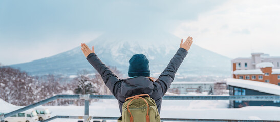 Woman tourist Visiting in Niseko, Traveler in Sweater sightseeing Yotei Mountain with Snow in winter season. landmark and popular for attractions in Hokkaido, Japan. Travel and Vacation concept - obrazy, fototapety, plakaty