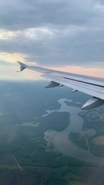 Vertical drone view from an airplane window of an airplane wing and landscapes