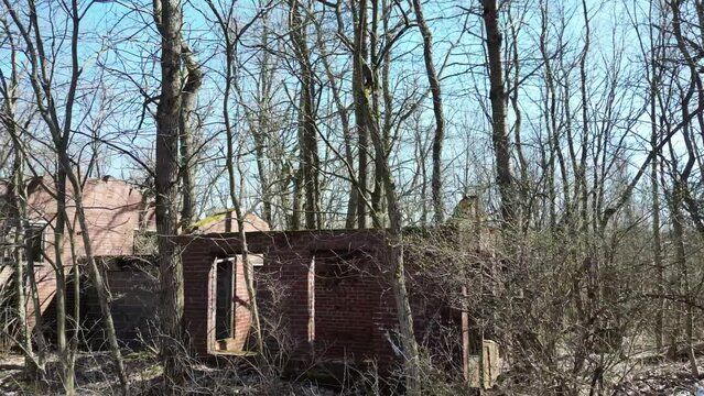 Red brick abandoned building surrounded by leafless trees in Centralia, Pennsylvania