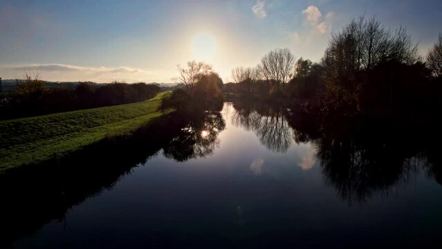 Aerial drone cinematic clip of a winter sunset on a calm river.