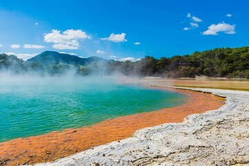 the pool in front of the crater has red water and steamy springs