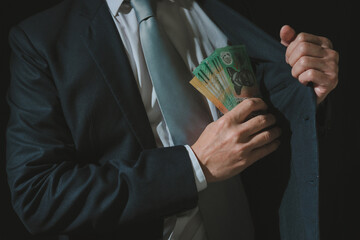 Financial Power: Businessman Handling Cash in Suit Pocket, Symbolizing Business Success