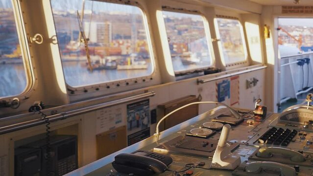 4K scene from inside bridge of anchored ship. Port seen through windows of ship's wheelhouse. Pilothouse equipment stock video.