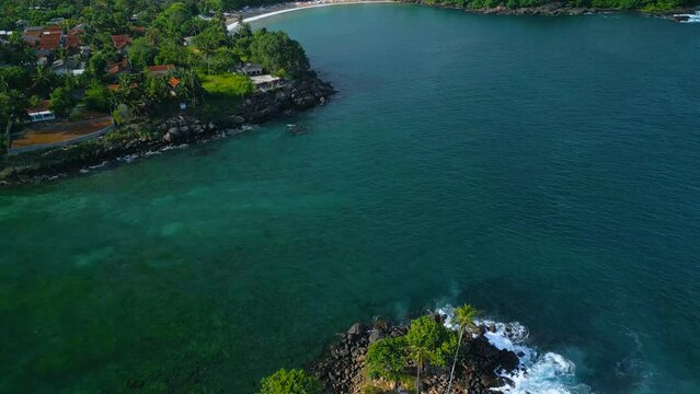 Aerial video of Dondra Lighthouse surrounded by tropical trees and the sea, Sri Lanka