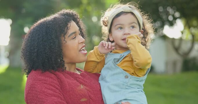 Family, children and a woman with her adopted daughter in the garden of their foster home together. Love, smile and kids with a happy mother holding her female child outdoor in the home backyard