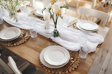 Wedding table and white chairs adorned with flowers