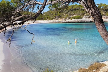 Children playing in the crystal clear water of the sea on a sunny day