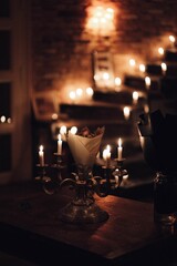 Single lit candle illuminated by other burning candles in a darkened room