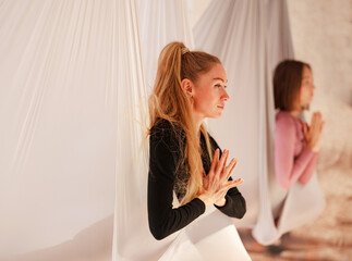 workshop of air yoga and stretching in yoga studio. women practices different inversion antigravity...