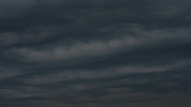 Dense Night Cloudiness. Time-Lapse. Time-Lapse. Dark, leaden-toned clouds move fast in the evening sky, backlit by the setting sun