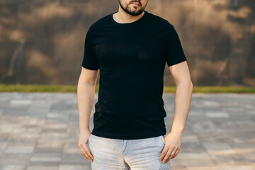 Young stylish bearded man  in a black T-shirt and sunglasses. Street photo