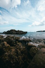 Stunning view of the ocean with its waves crashing against the rocks on a sunny day