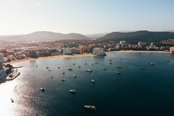 Fototapeta premium Scenic view of multiple traditional-style fishing boats drifting in the sea in Mallorca, Spain