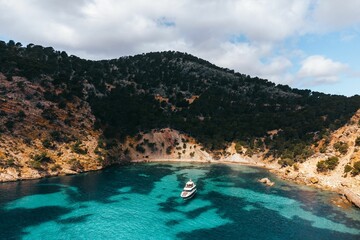 Aerial view of a small boat with a picturesque backdrop of buildings in Mallorca, Spain