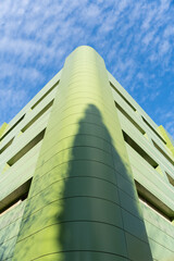 Green facade of a futuristic building. The original building is green in color. View from below of...