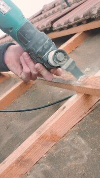 Vertical of a person cutting wood with an Oscillating Multi-Tool