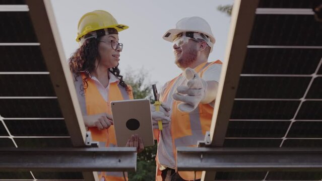 tecnicos vestindo equipamentos de protecao instalando paineis de energia solar em uma propriedade rural no Brasil