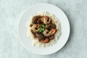Delicious and healthy meal of freshly cooked rice with shrimp and vegetables served on a white plate