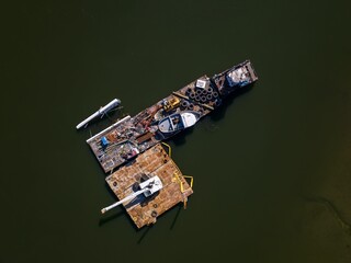 Rusty industrial barge with a crane and tires on it, in the Hutchinson River in the Bronx, New York