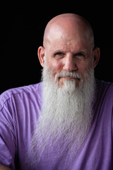 Portrait of man with long gray beard wearing purple t-shirt close-up shot